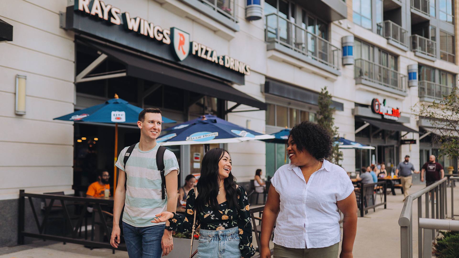 People walking in front of retail shops at Midtown Crossing