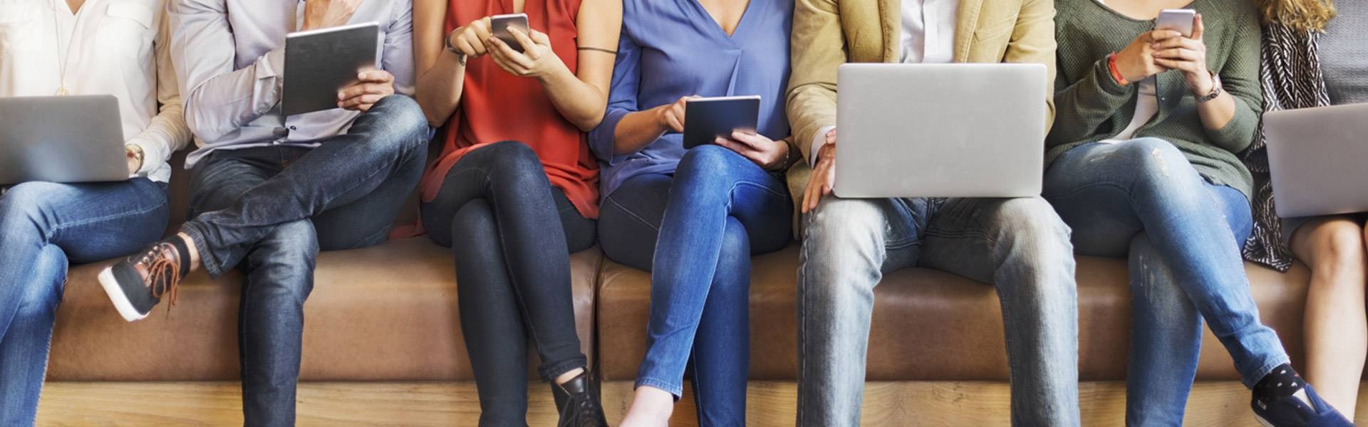 People on laptops sitting on couch