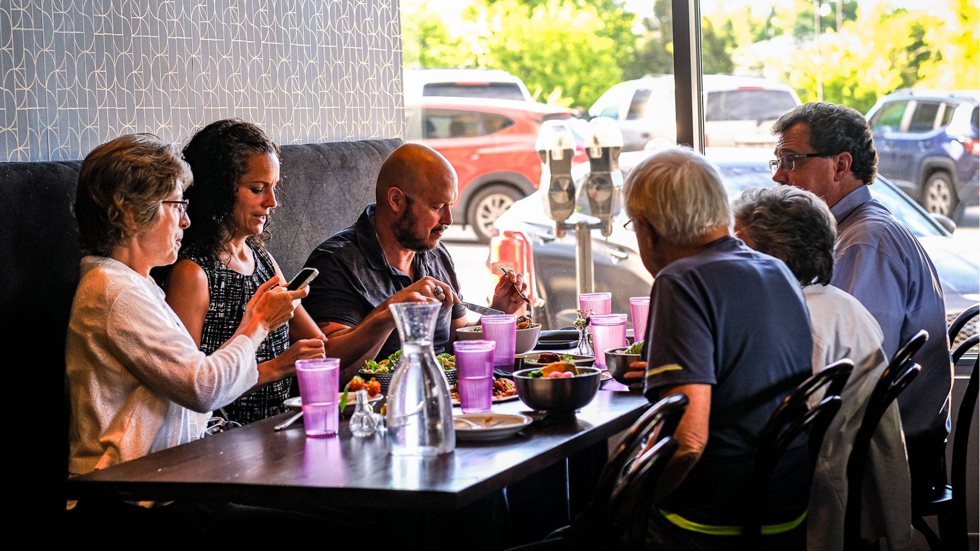 Group of people dining at Modern Love, Omaha's premier vegan/ plant-based restaurant, located at Midtown Crossing